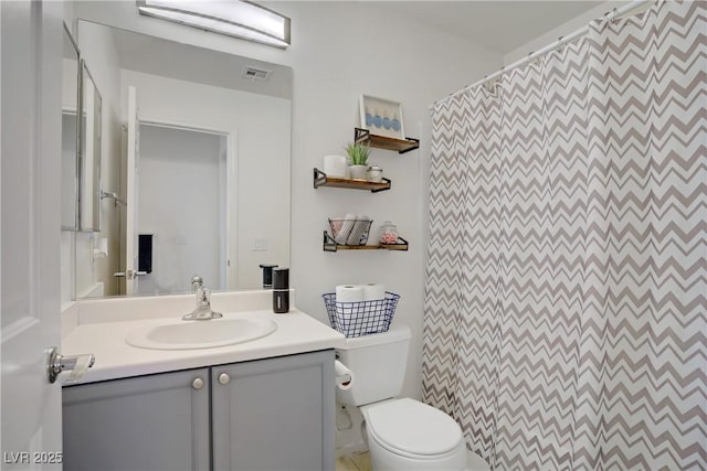 bathroom featuring vanity, curtained shower, visible vents, and toilet