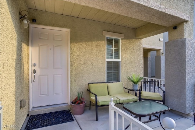 doorway to property featuring stucco siding and outdoor lounge area