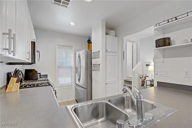kitchen with visible vents, a sink, white cabinets, stainless steel appliances, and recessed lighting