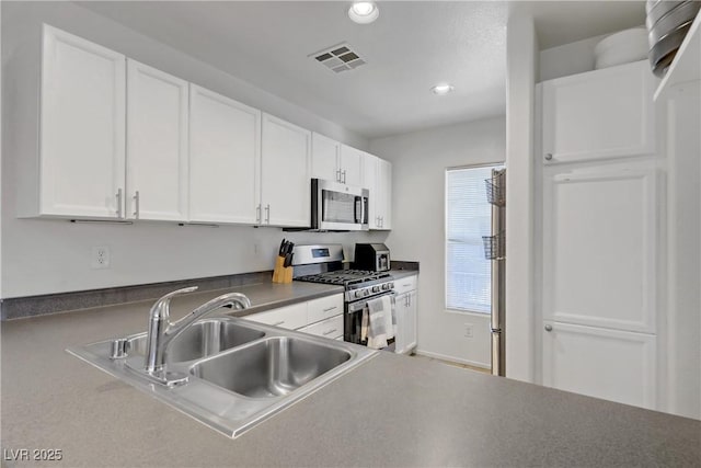 kitchen featuring visible vents, a sink, stainless steel appliances, recessed lighting, and white cabinetry
