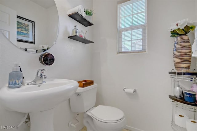 half bathroom with toilet and baseboards