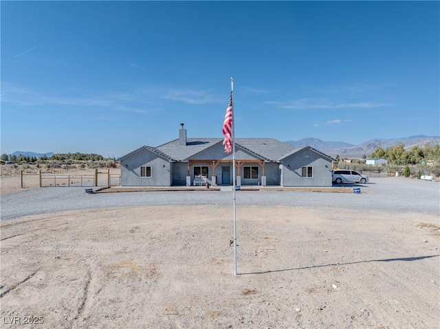3880 Rudek St, Pahrump, NV 89061 - view of front facade with a mountain view, a chimney, stucco siding, and a tiled roof