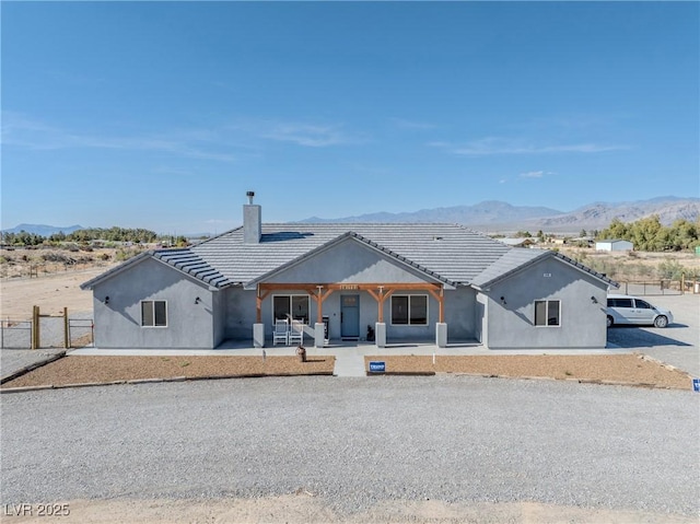 3880 Rudek St, Pahrump, NV 89061 - rear view of property with fence, a mountain view, a chimney, and stucco siding