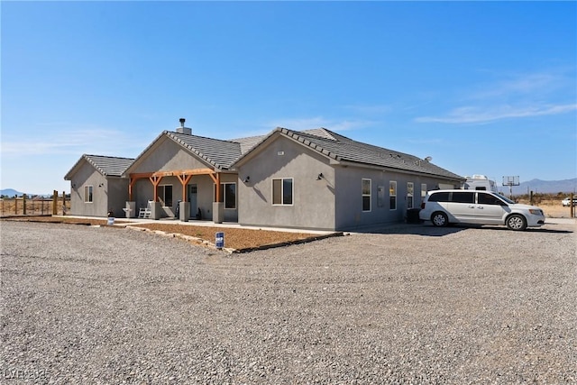 3880 Rudek St, Pahrump, NV 89061 - view of front facade featuring a chimney, stucco siding, a mountain view, and a tile roof