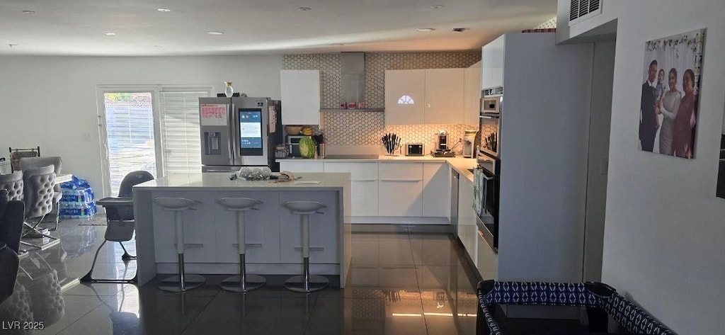 kitchen with visible vents, dark tile patterned floors, white cabinets, and stainless steel fridge with ice dispenser