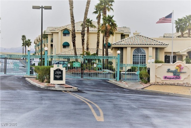 exterior space with curbs and a gate