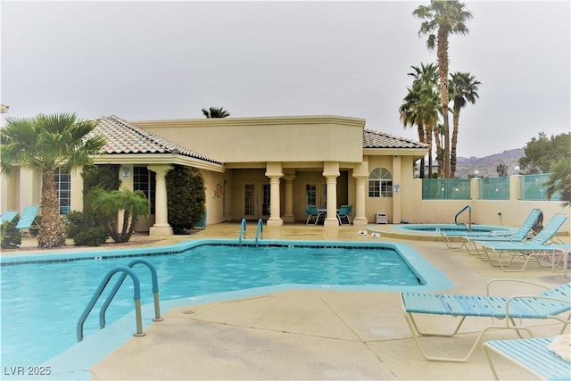pool featuring a mountain view, fence, and a patio area