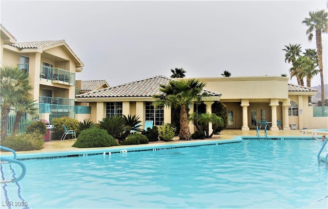 community pool featuring fence and a patio area