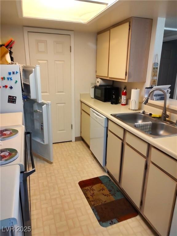kitchen with light countertops, a sink, brick patterned floor, and white appliances