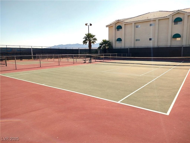 view of sport court featuring fence, a mountain view, and community basketball court
