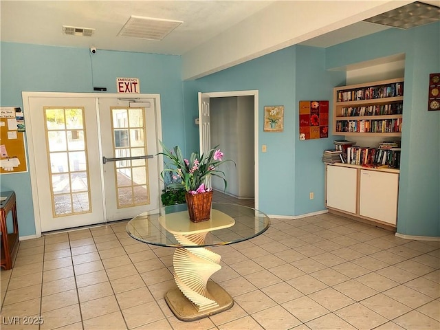 entryway with visible vents, light tile patterned floors, and french doors