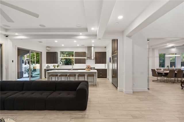 living area featuring light wood-style flooring, baseboards, and recessed lighting