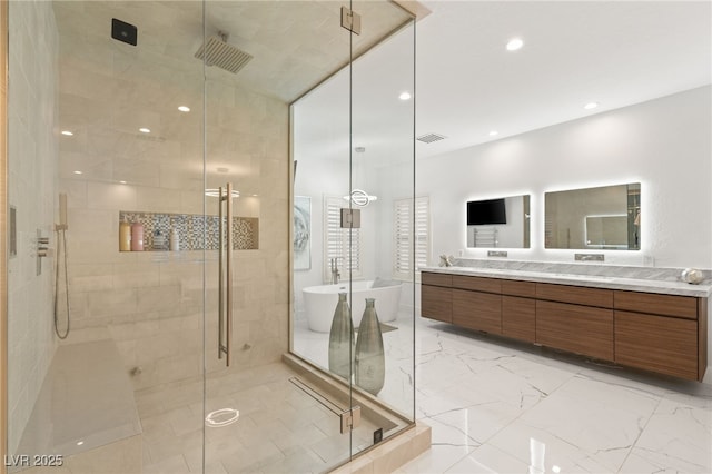 bathroom with a shower stall, a freestanding tub, vanity, marble finish floor, and recessed lighting