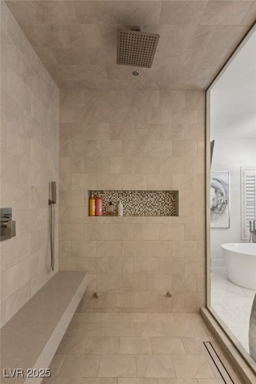 bathroom featuring a soaking tub and tiled shower