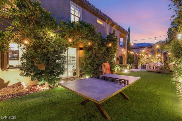 yard at dusk with a patio area and an outdoor living space