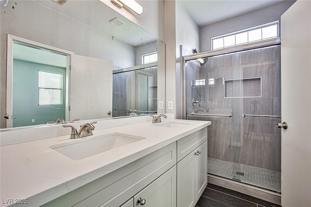 full bath with a shower stall, a sink, and double vanity