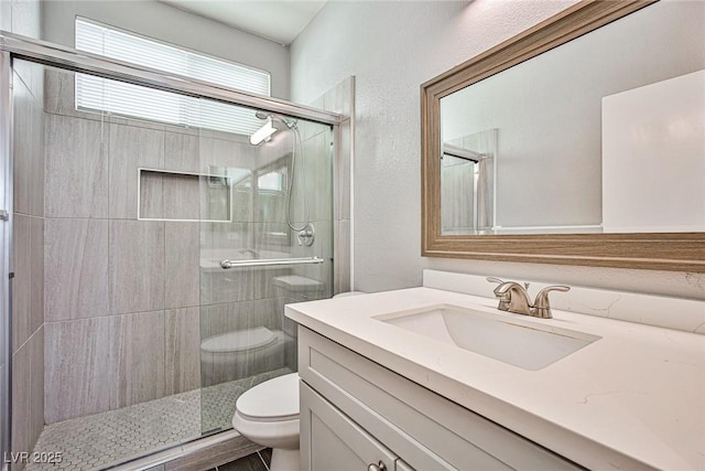 full bath featuring vanity, a shower stall, and toilet