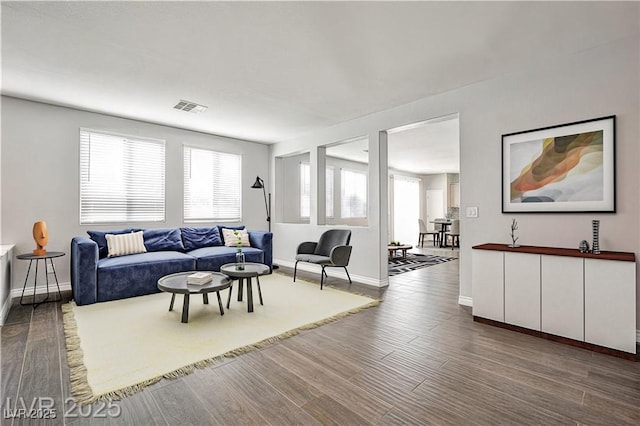 living room featuring wood finished floors, visible vents, and baseboards