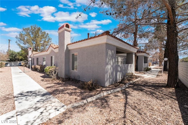 1838 N Jones Blvd, Las Vegas, NV 89108 - view of side of property featuring stucco siding, a tile roof, and a chimney