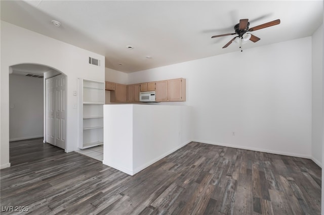 1838 N Jones Blvd, Las Vegas, NV 89108 - kitchen featuring white microwave, arched walkways, a ceiling fan, dark wood-style flooring, and light brown cabinetry