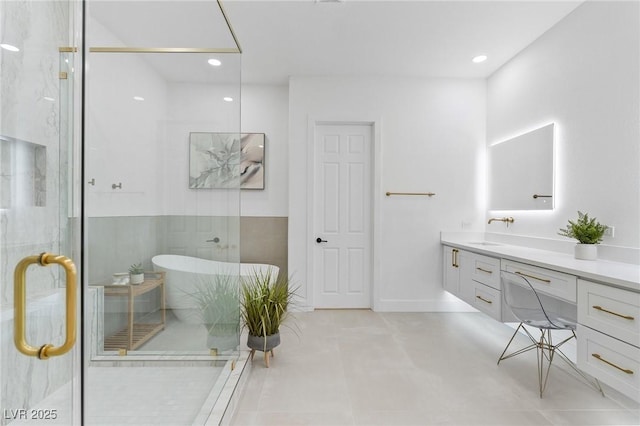 bathroom featuring recessed lighting, a shower stall, a freestanding tub, and vanity