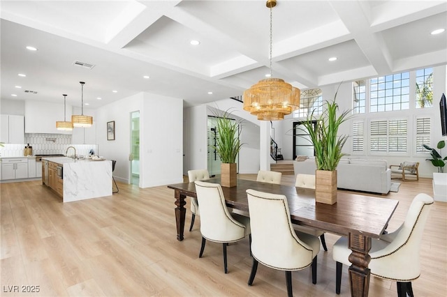 dining area featuring light wood-type flooring, an inviting chandelier, coffered ceiling, visible vents, and recessed lighting
