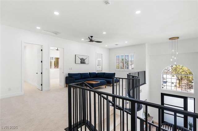 interior space with baseboards, recessed lighting, an upstairs landing, and light colored carpet
