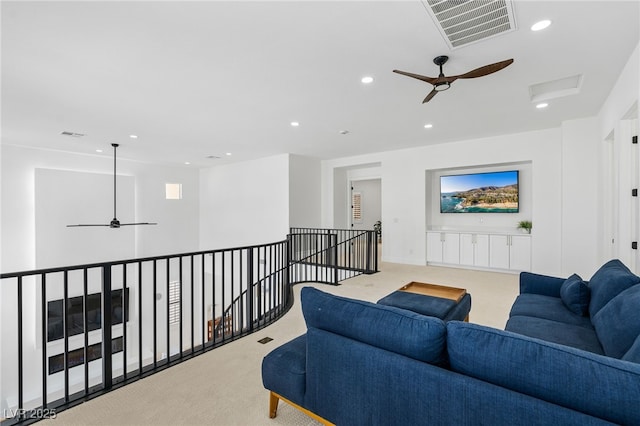 living area featuring visible vents, light carpet, and ceiling fan