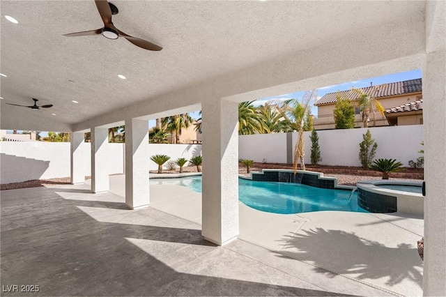 view of pool featuring ceiling fan, a fenced backyard, a pool with connected hot tub, and a patio