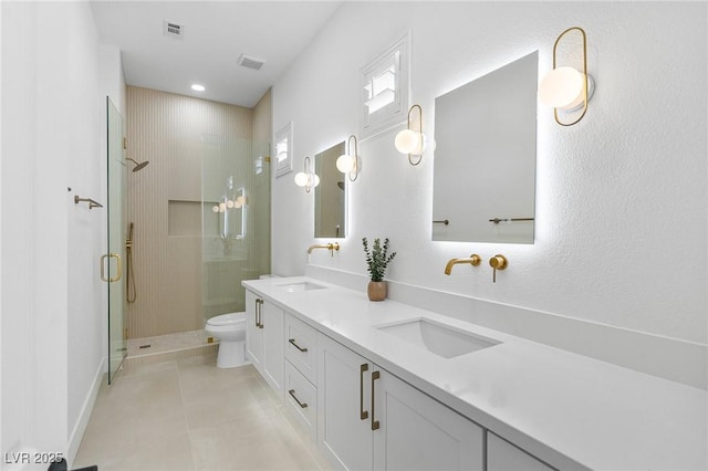 bathroom with a shower stall, toilet, a sink, and visible vents