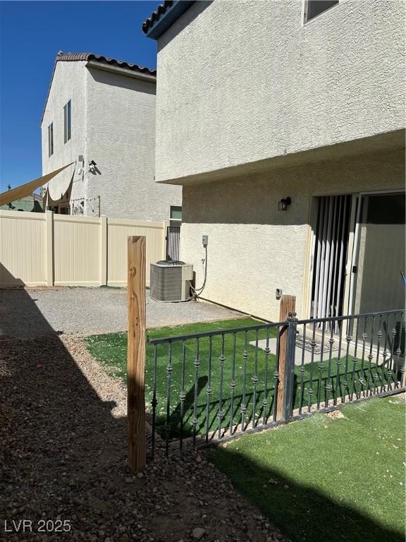 view of yard featuring fence and central AC