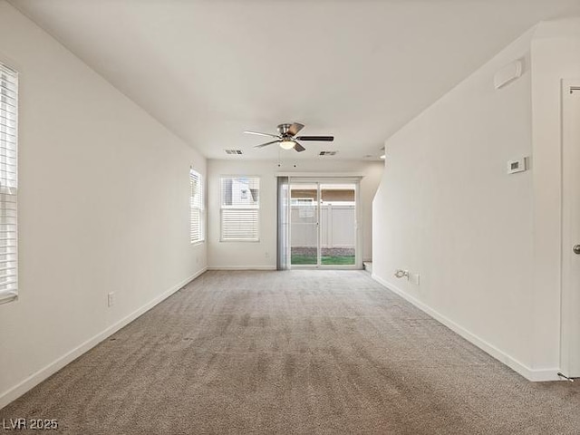 spare room featuring ceiling fan, baseboards, and light carpet