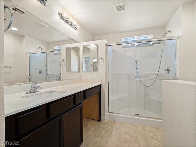 full bath with visible vents, a shower stall, and vanity