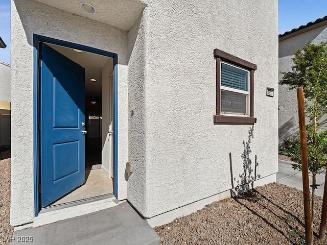 doorway to property featuring stucco siding