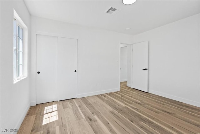 429 N 10th St, Las Vegas, NV 89101 - unfurnished bedroom featuring light wood-style flooring, multiple windows, and a closet