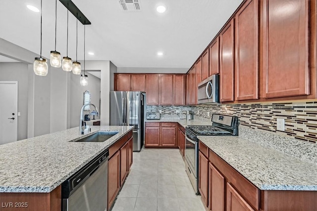 kitchen featuring backsplash, visible vents, appliances with stainless steel finishes, and a sink