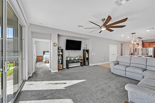 living area featuring ceiling fan, carpet flooring, and visible vents