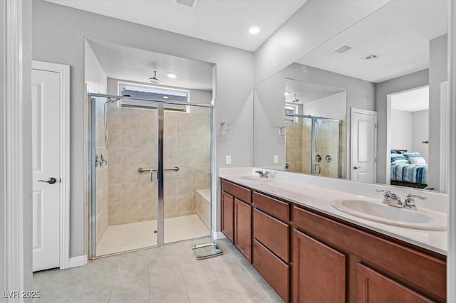 ensuite bathroom featuring a shower stall, tile patterned floors, a sink, double vanity, and ensuite bath