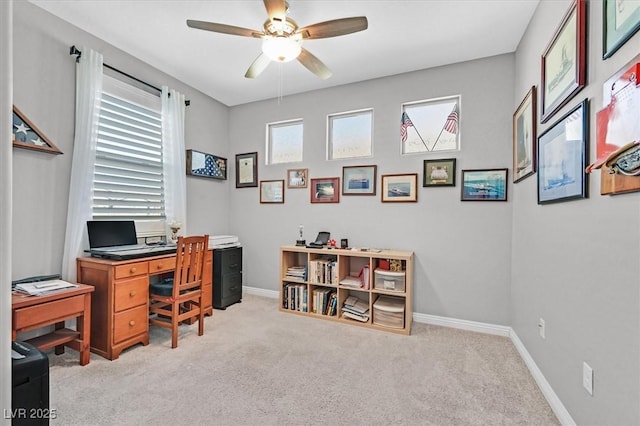 carpeted office featuring baseboards, a ceiling fan, and a healthy amount of sunlight