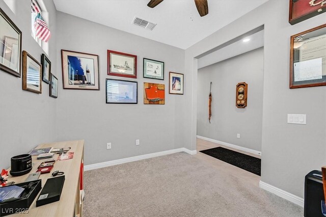 interior space with baseboards, a ceiling fan, and visible vents