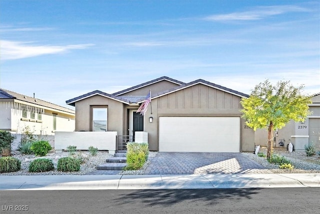 ranch-style house with stucco siding, an attached garage, and driveway