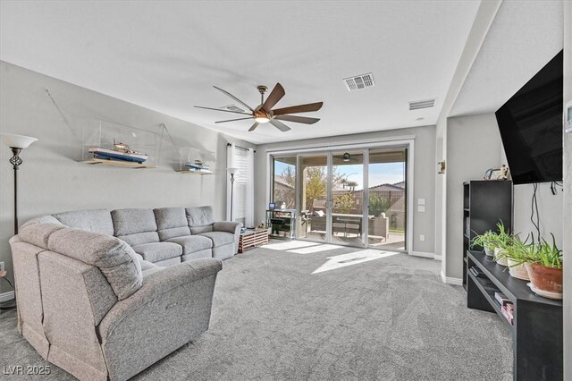 carpeted living area with visible vents, baseboards, and ceiling fan