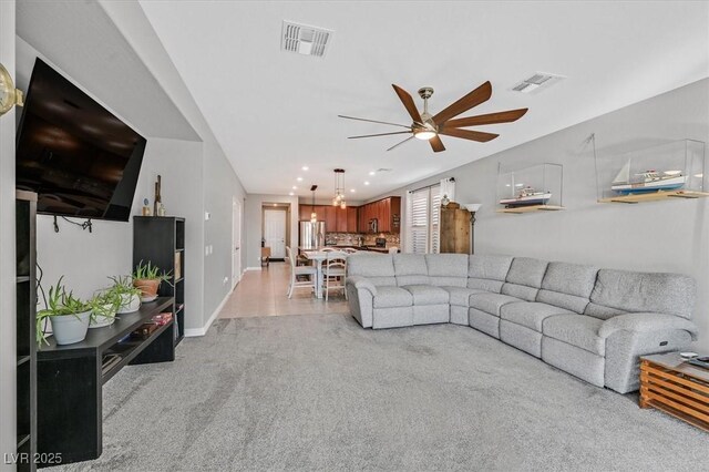 living room with light colored carpet, ceiling fan, baseboards, and visible vents