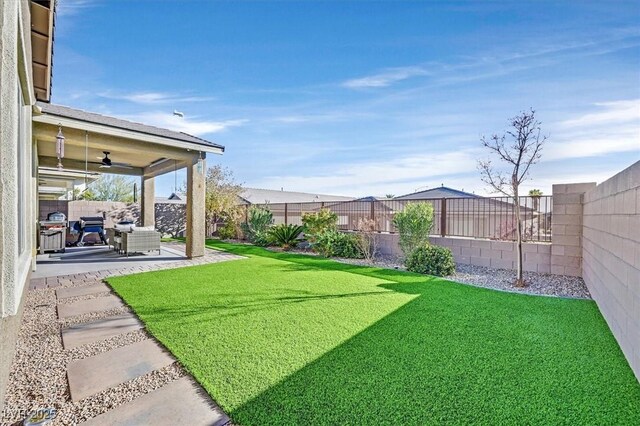 view of yard with a patio area, a fenced backyard, and ceiling fan