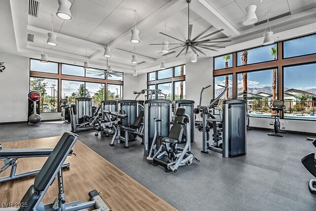 exercise room with coffered ceiling, a ceiling fan, and visible vents