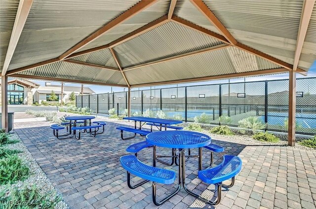 view of patio / terrace with a gazebo, fence, and a tennis court
