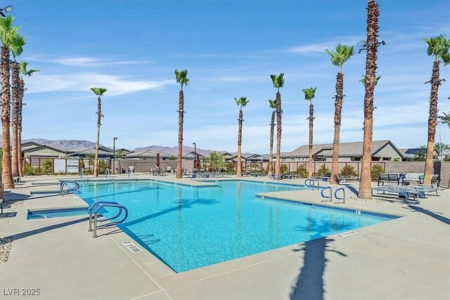 community pool featuring fence, a patio area, and a residential view