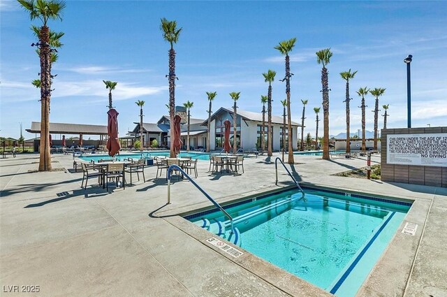 pool featuring a hot tub and a patio
