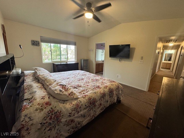 2807 Camelback Ln, Henderson, NV 89074 - carpeted bedroom with ensuite bath, vaulted ceiling, baseboards, and ceiling fan