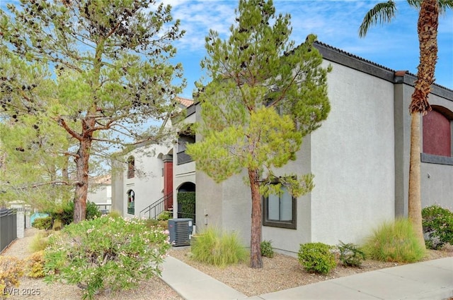 view of front of house featuring stucco siding and central AC unit